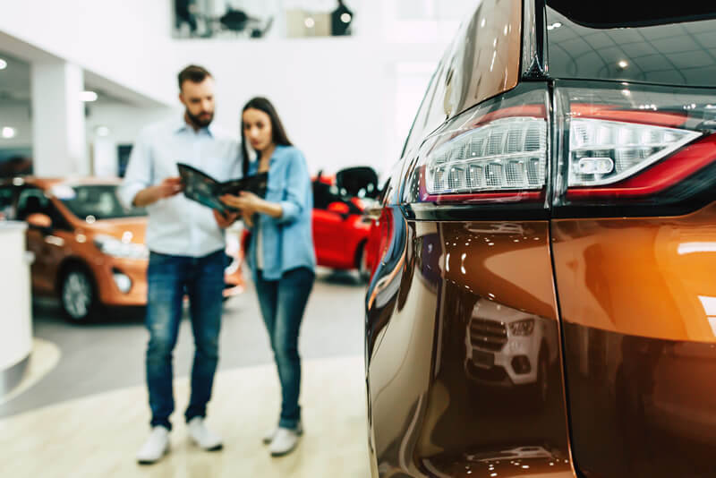 A couple explores an auto dealership
