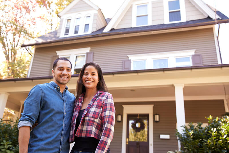 A couple standing outside their home