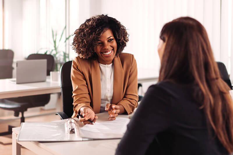 A woman meets with a loan officer.